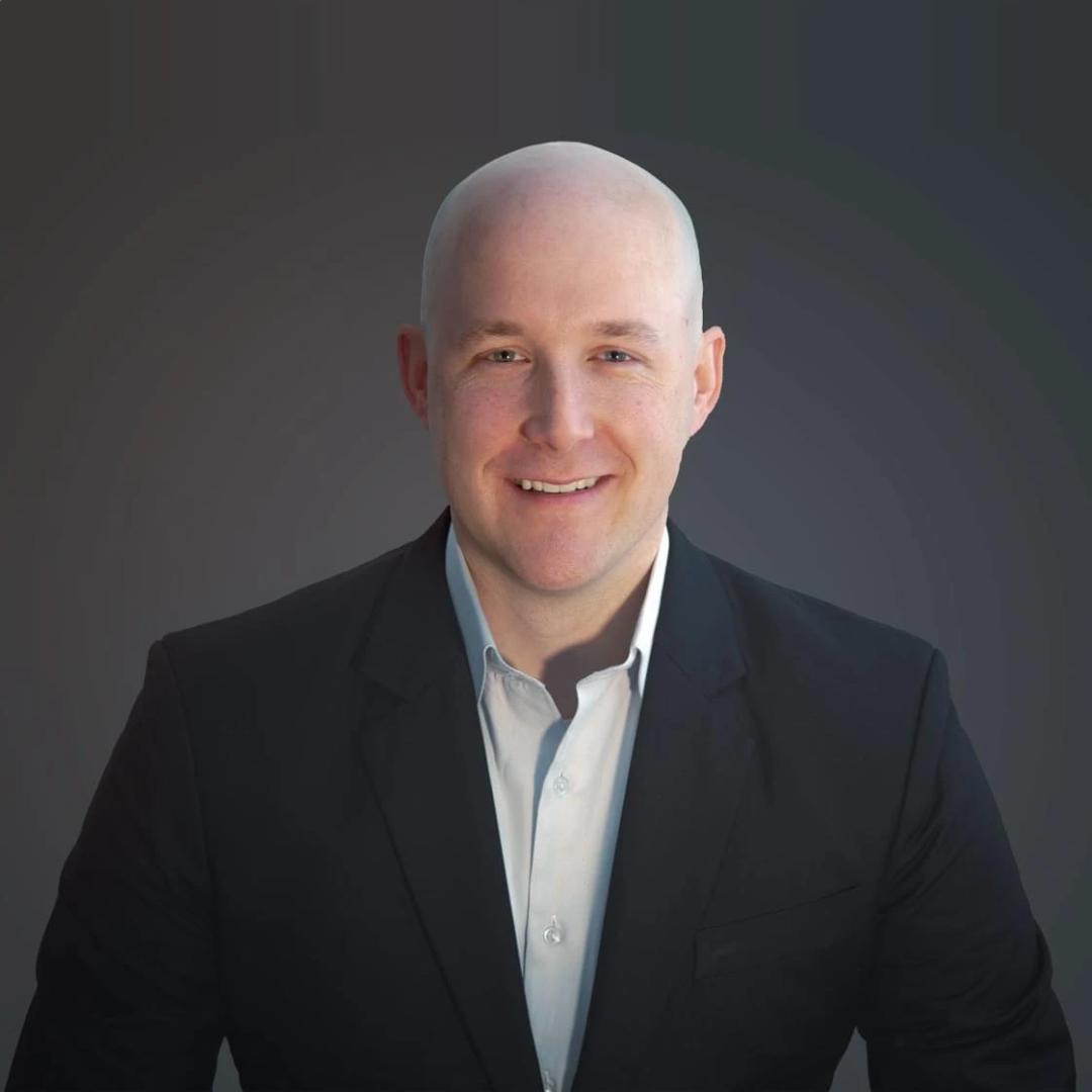 bald man in a suit and tie posing for a picture