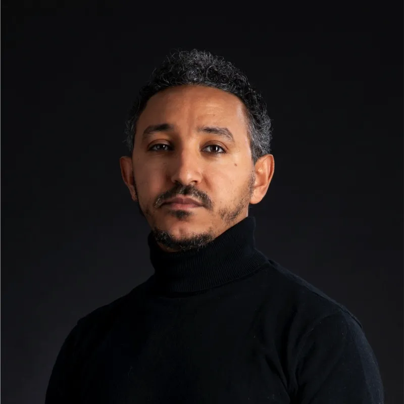 man in a black turtle neck sweater posing for a picture